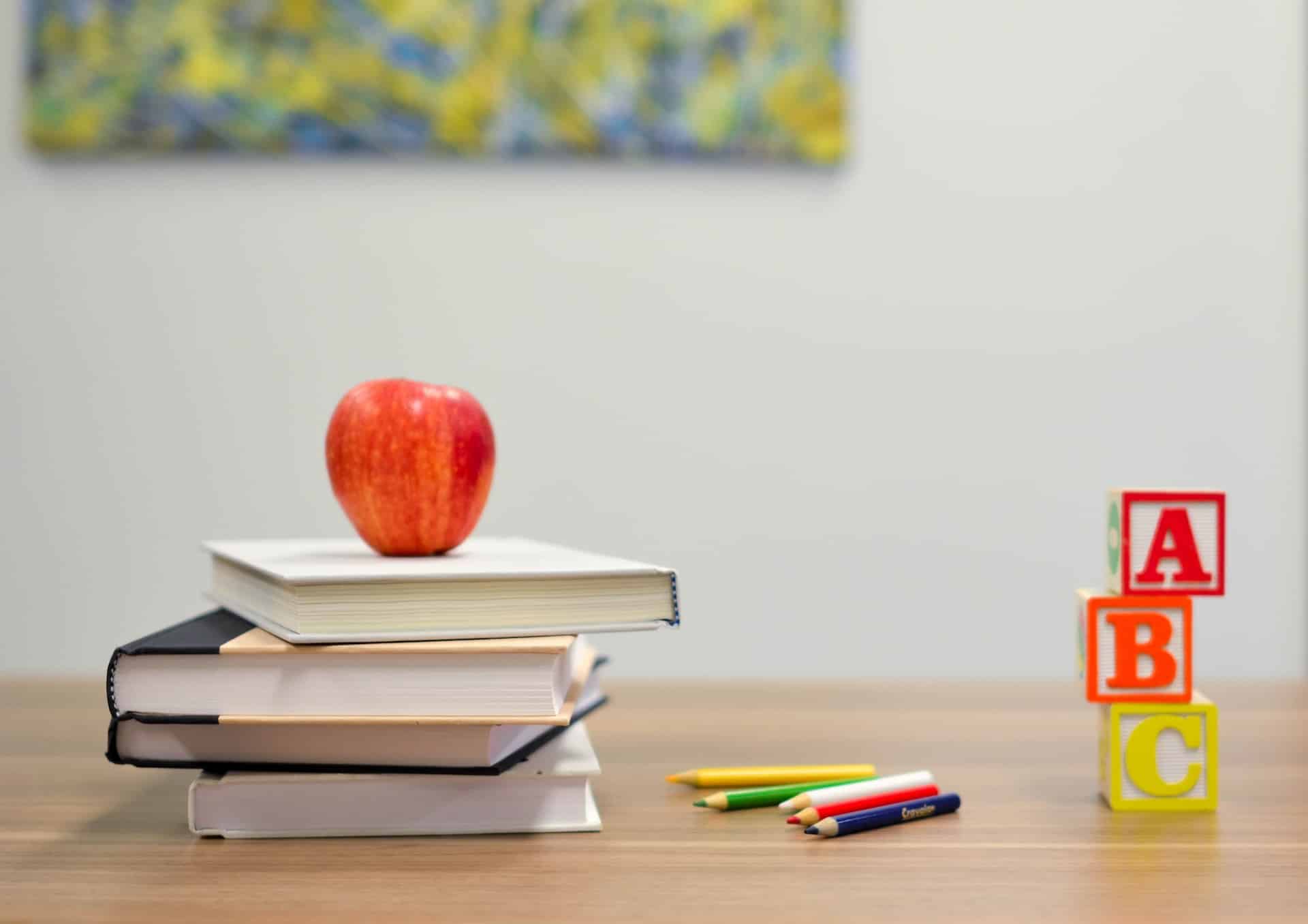 photo of teachers desk with apple and books representing discrimination based on family status