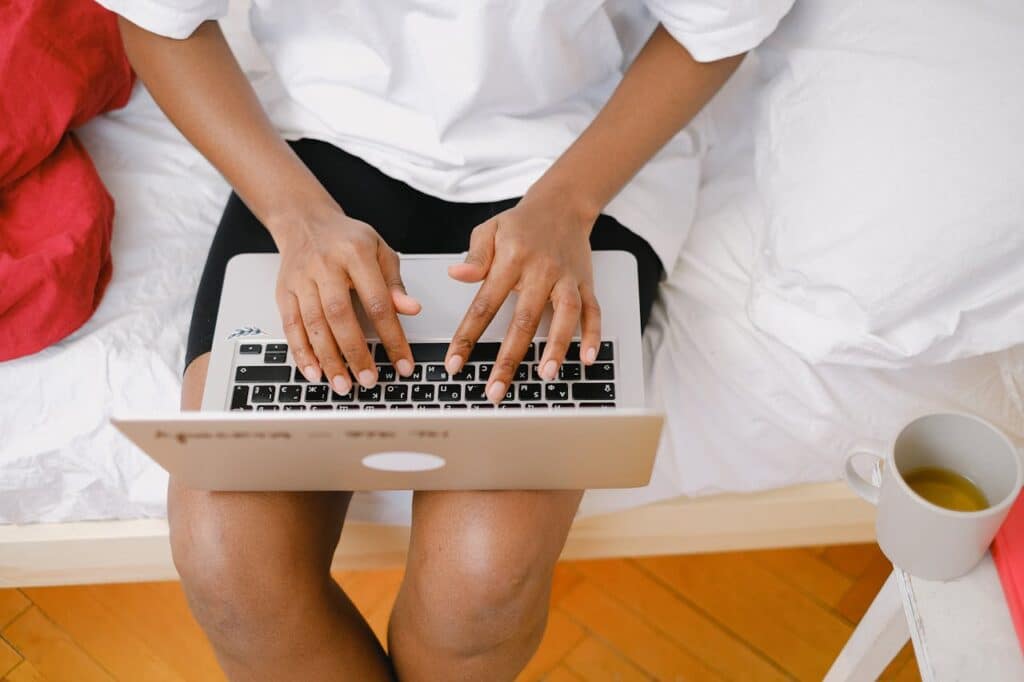 photo of employee working on computer in bed representing workplace accommodation requests