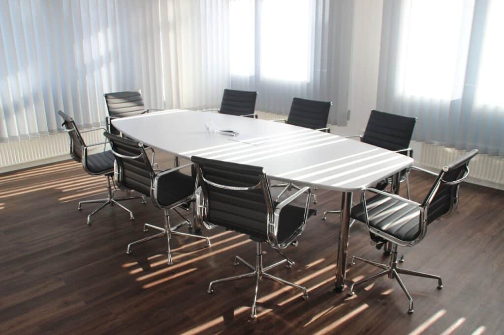 Photo of empty board room table and chairs representing a company's restructuring