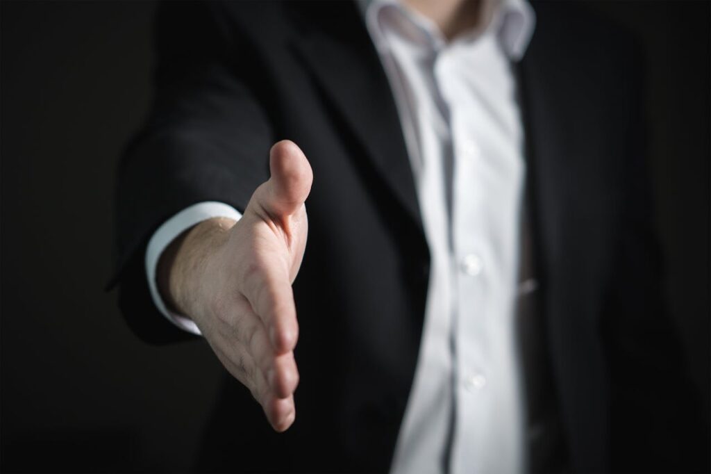 a person offering a handshake representing the benefits of legal mediation