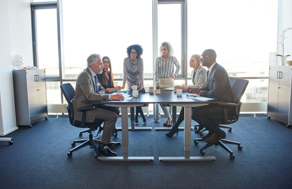 Several people gathered around a business table engaged in a discussion, representing employment mediation and arbitration in Windsor-Essex County