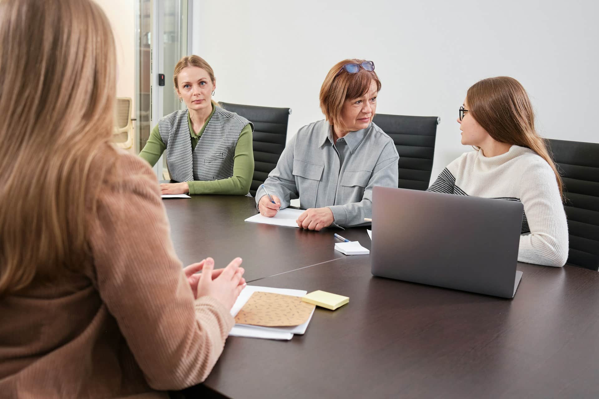 View from behind an interviewee job applicant being interviewed by a panel of three women, representing the Working for Workers Five Act in Ontario