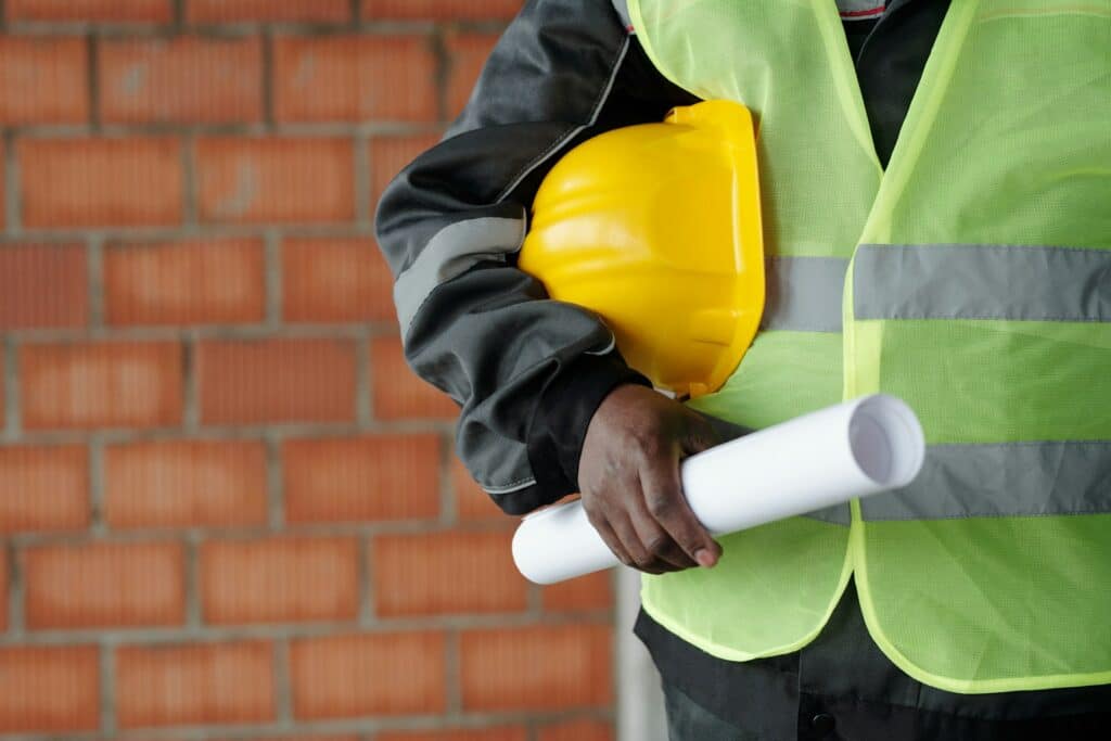 A man holding a construction hat and blueprints, representing environmental due diligence.