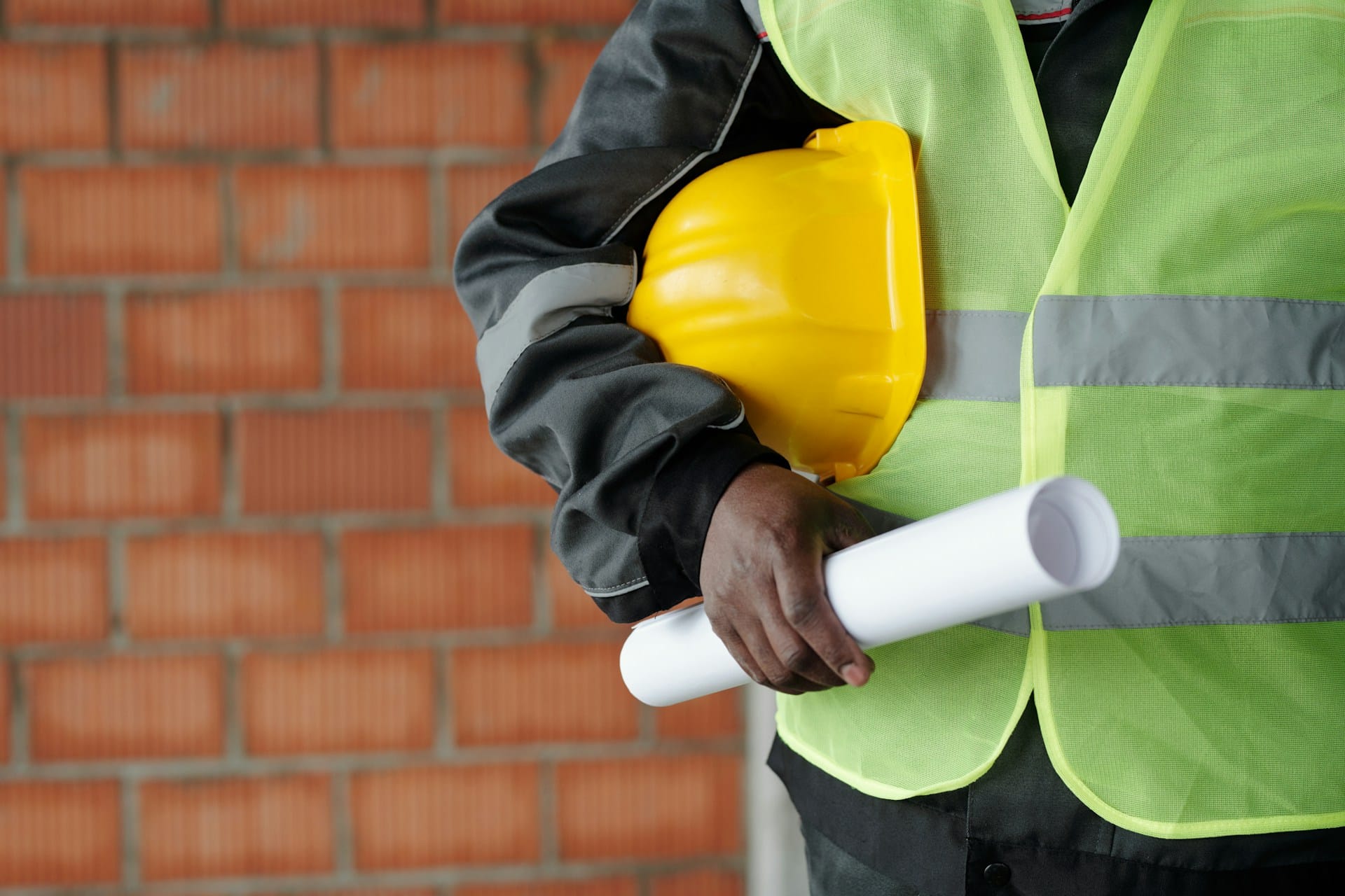 A man holding a construction hat and blueprints, representing environmental due diligence.