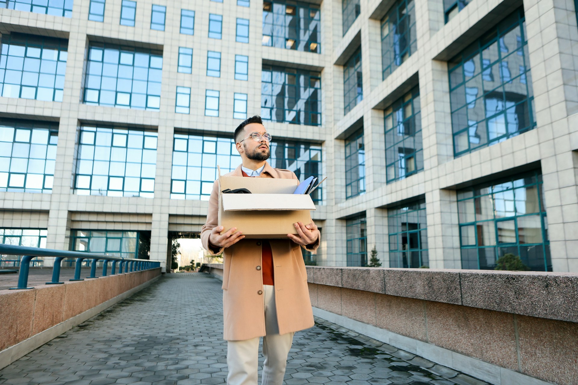 An employee leaving his job with a box full of personal effects, representing employers protecting their businesses after an employee leaves to join a competitor in Ontario.